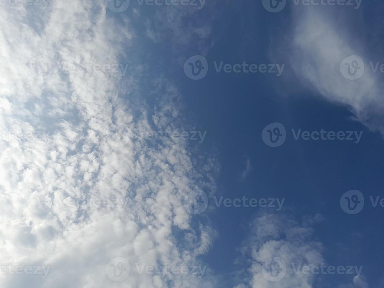 Beautiful white clouds on deep blue sky background. Large bright soft fluffy clouds are cover the entire blue sky. photo