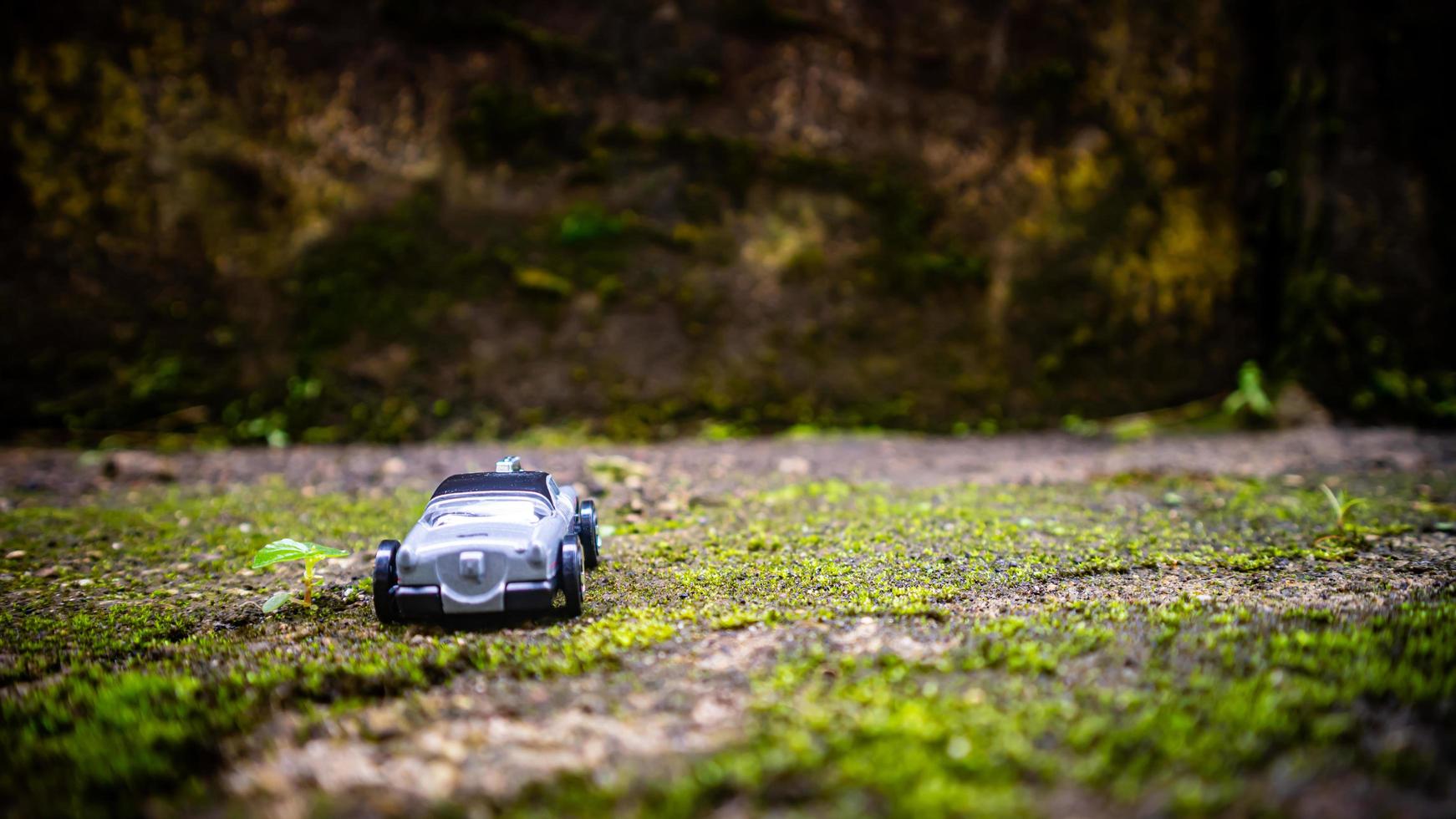 South Minahasa, Indonesia  January 2023, a toy car on a mossy floor that looks like grass photo