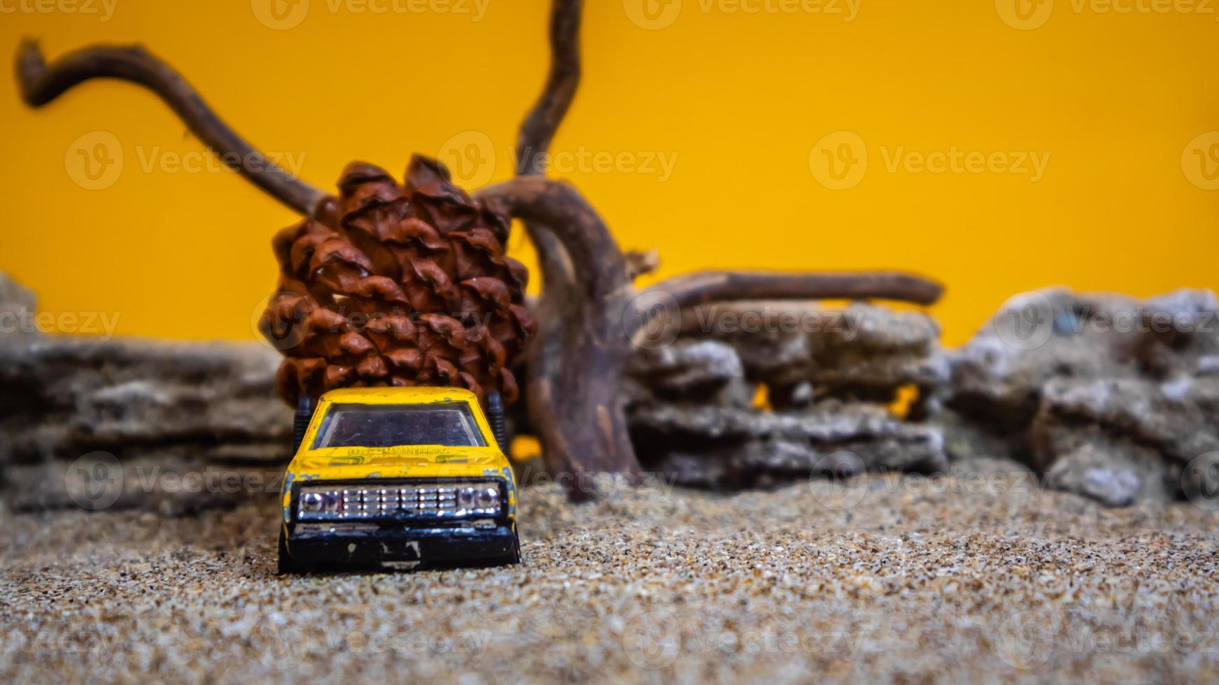 coche de juguete que transporta piñas sobre un fondo naranja foto