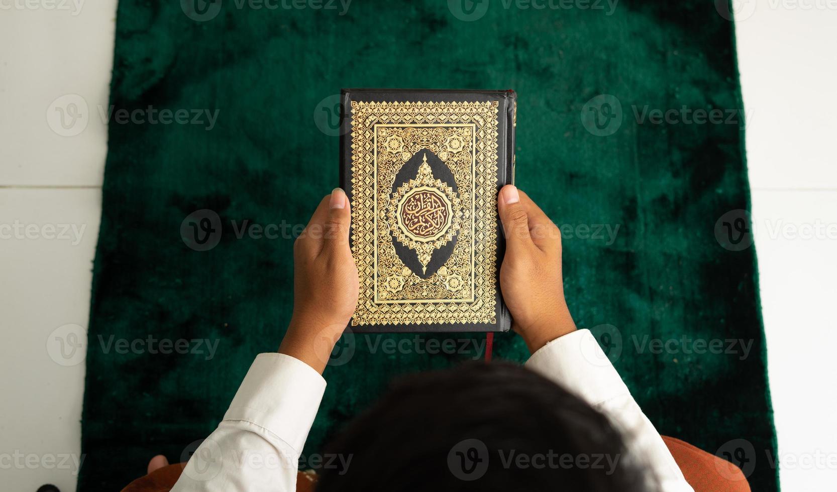 Man holding Quran book in top angle photo