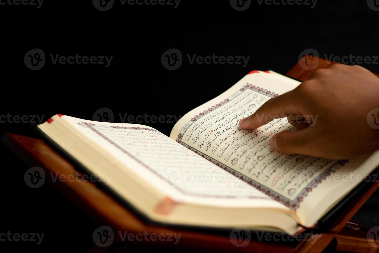 praying hands on a Quran book photo