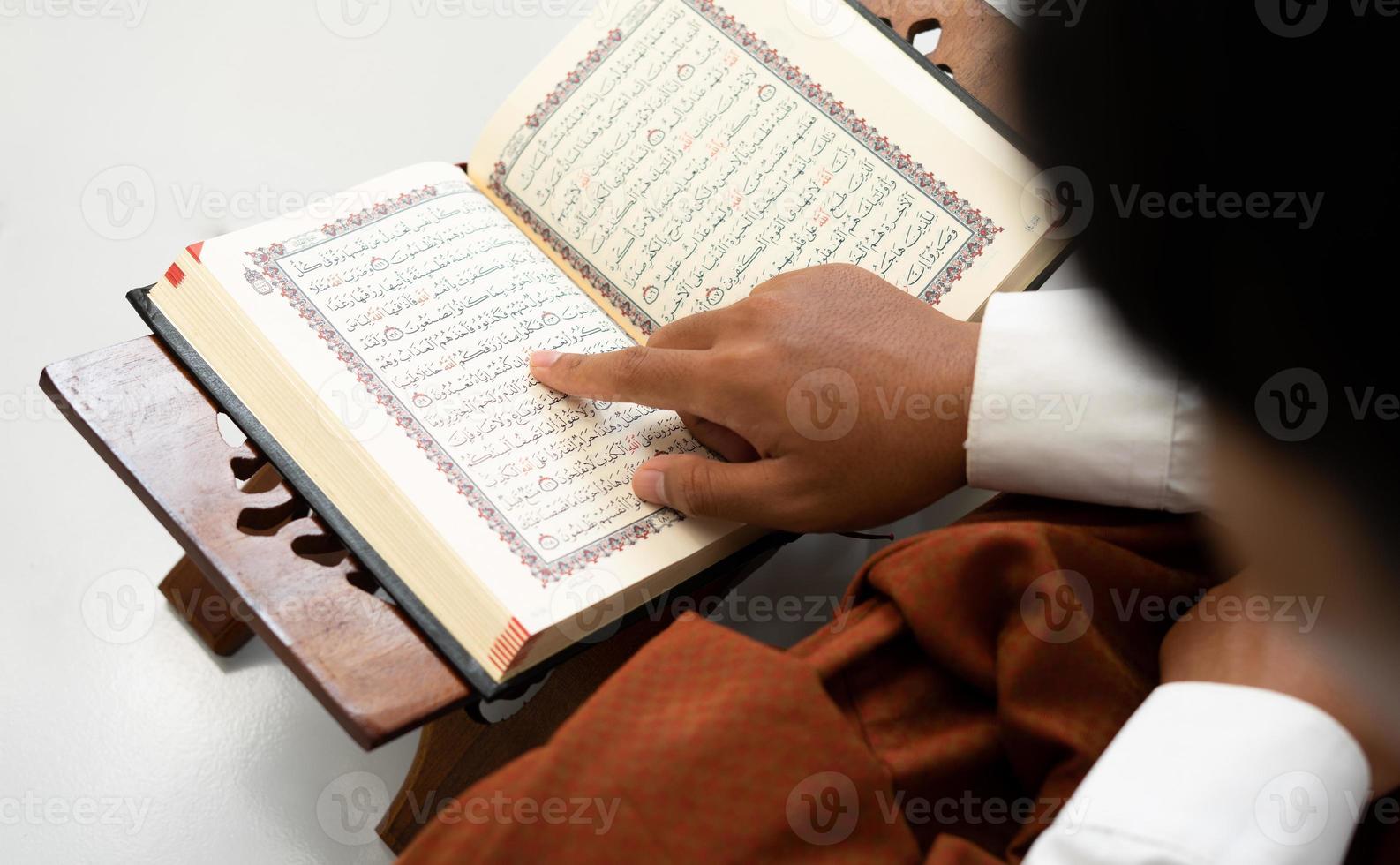 person reading holy Quran book photo