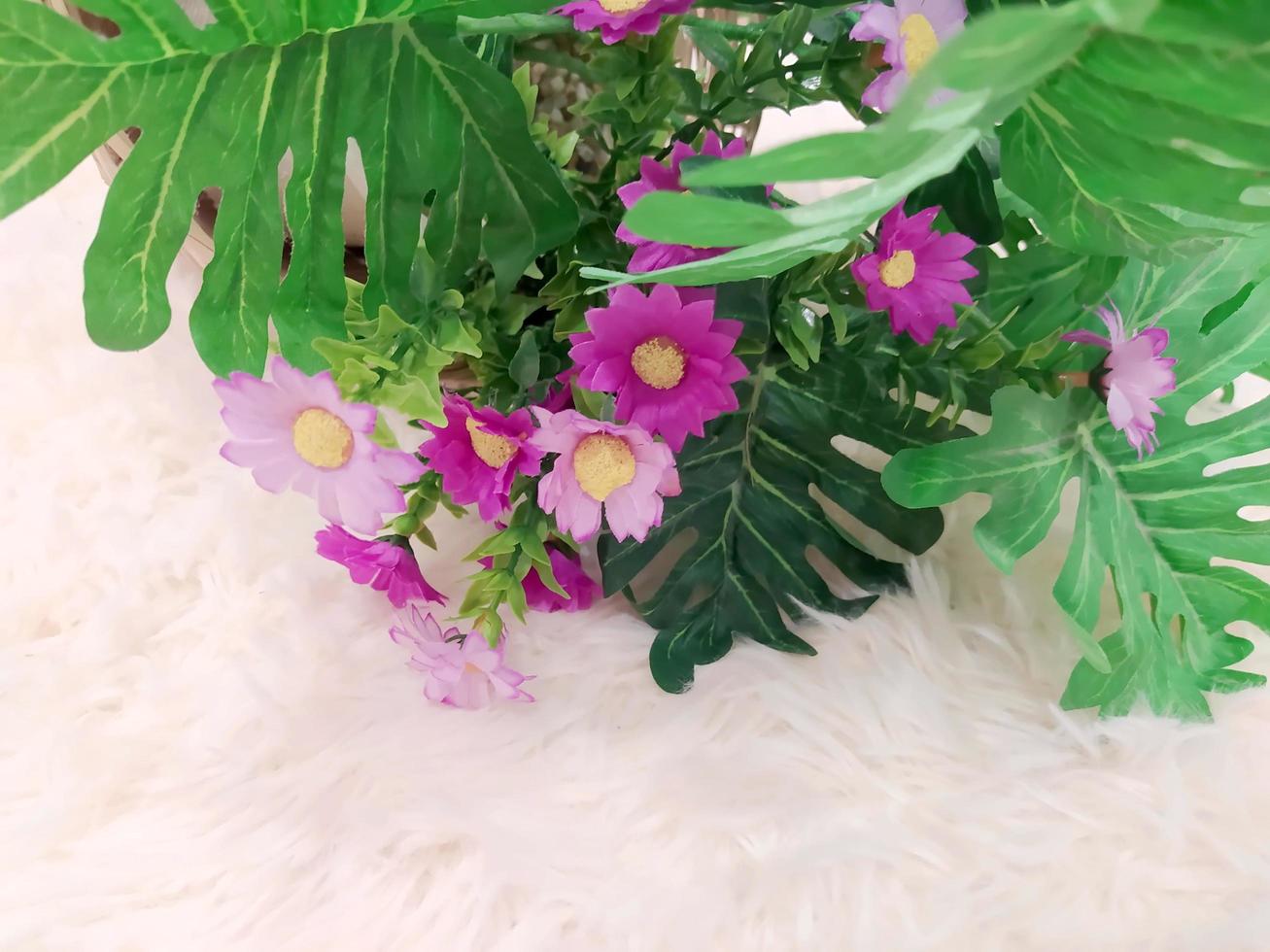 Close-up of artificial flowers on a light-colored carpet. photo