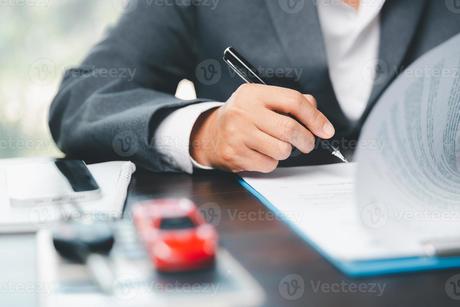 Car dealer business woman signing car insurance document or lease paper. Planning to manage transportation finance costs. Concept of car insurance business, saving buy with tax and loan for new car. photo