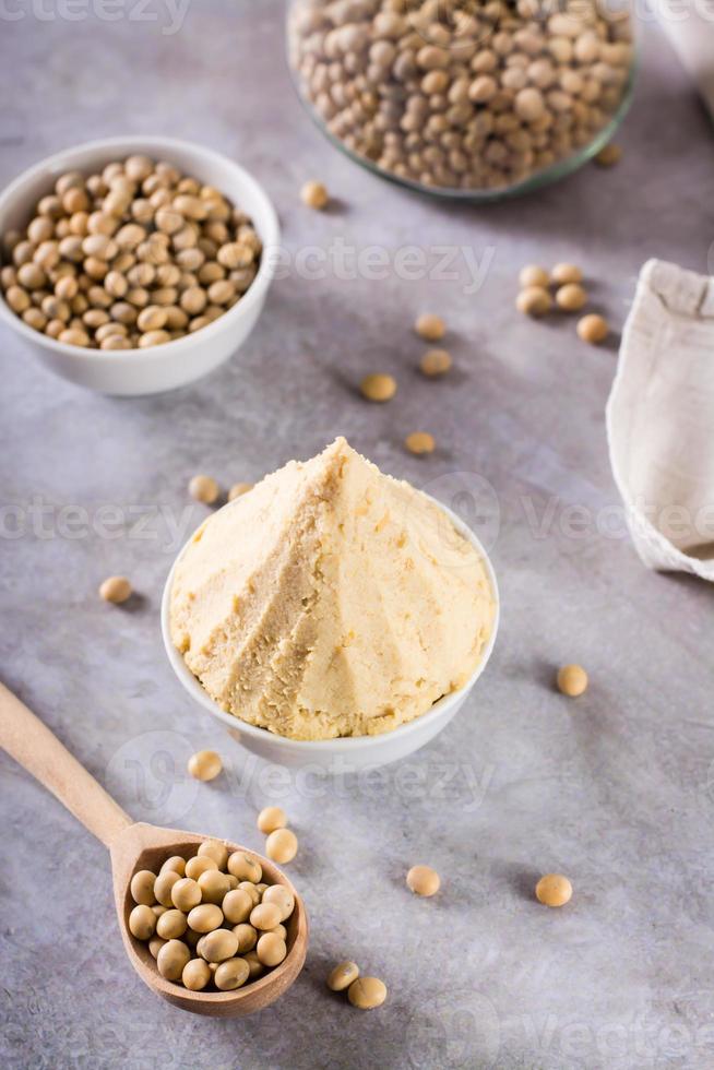 Traditional fermented soy miso seasoning in a bowl on the table. Japanese food. Vertical view photo