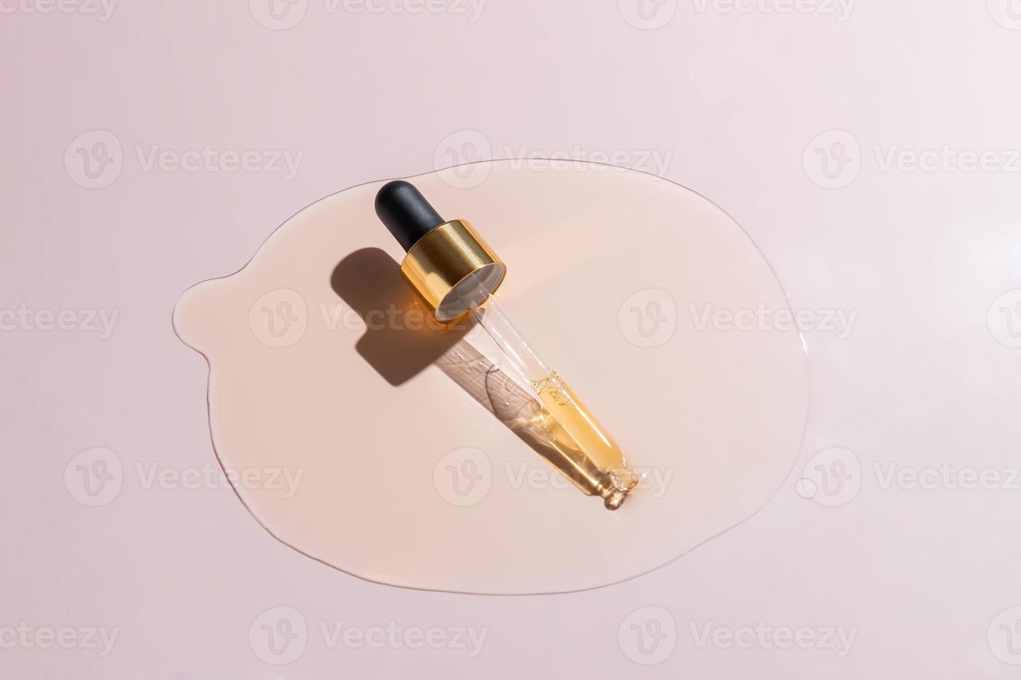 Cosmetic serum gel beauty drop and cosmetic pipette on pink background. Skincare beauty product with bubbles texture. photo