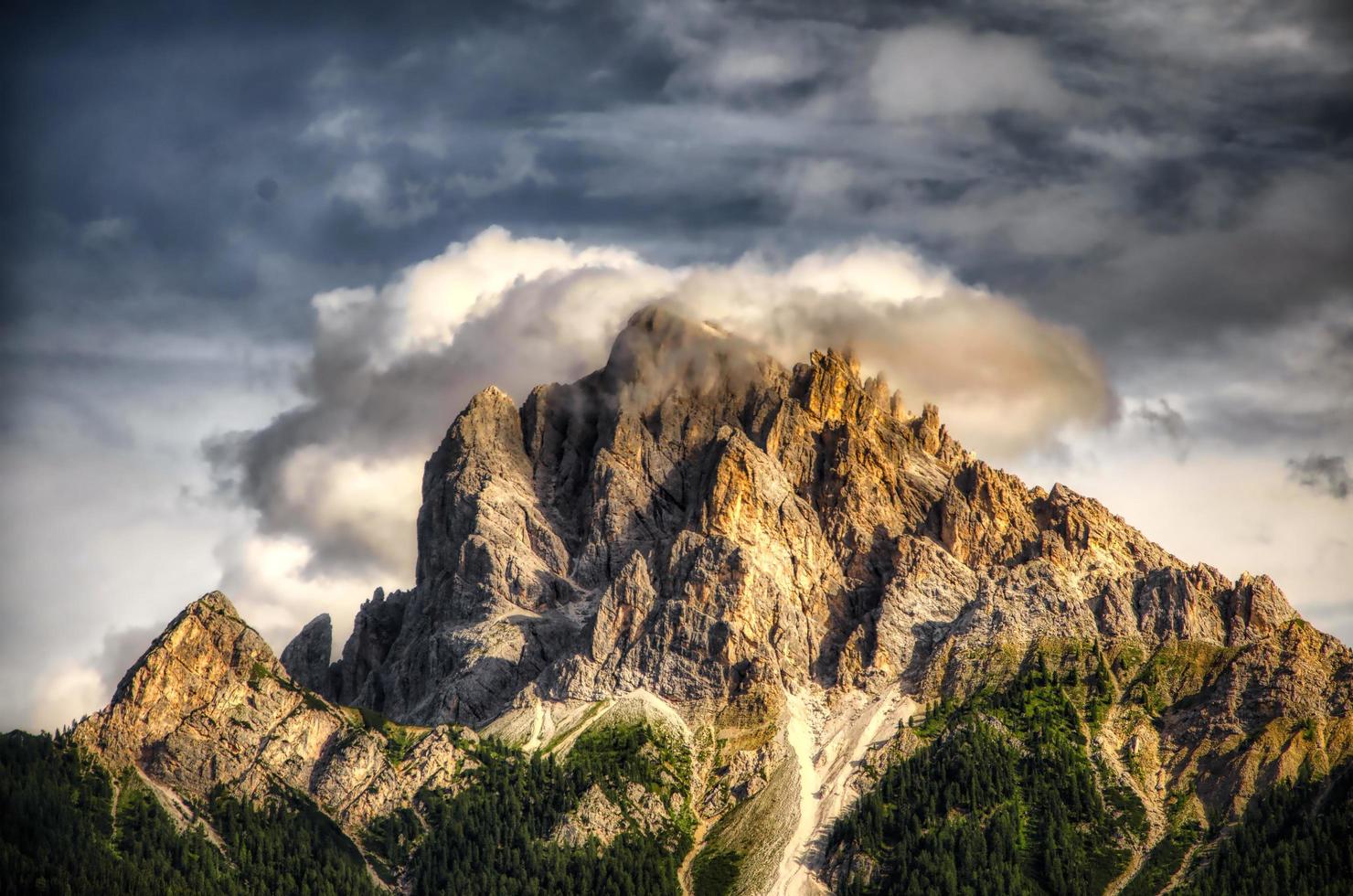 dolomita montañas a puesta de sol rodeado por nubes en un verano noche foto