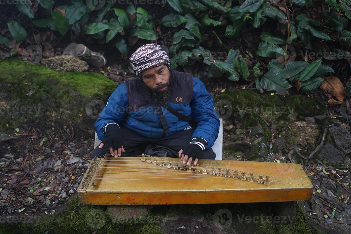 a man playing kecapi traditional Sundanese music in the  Ciwidey, Bandung,west java,  indonesia. photo