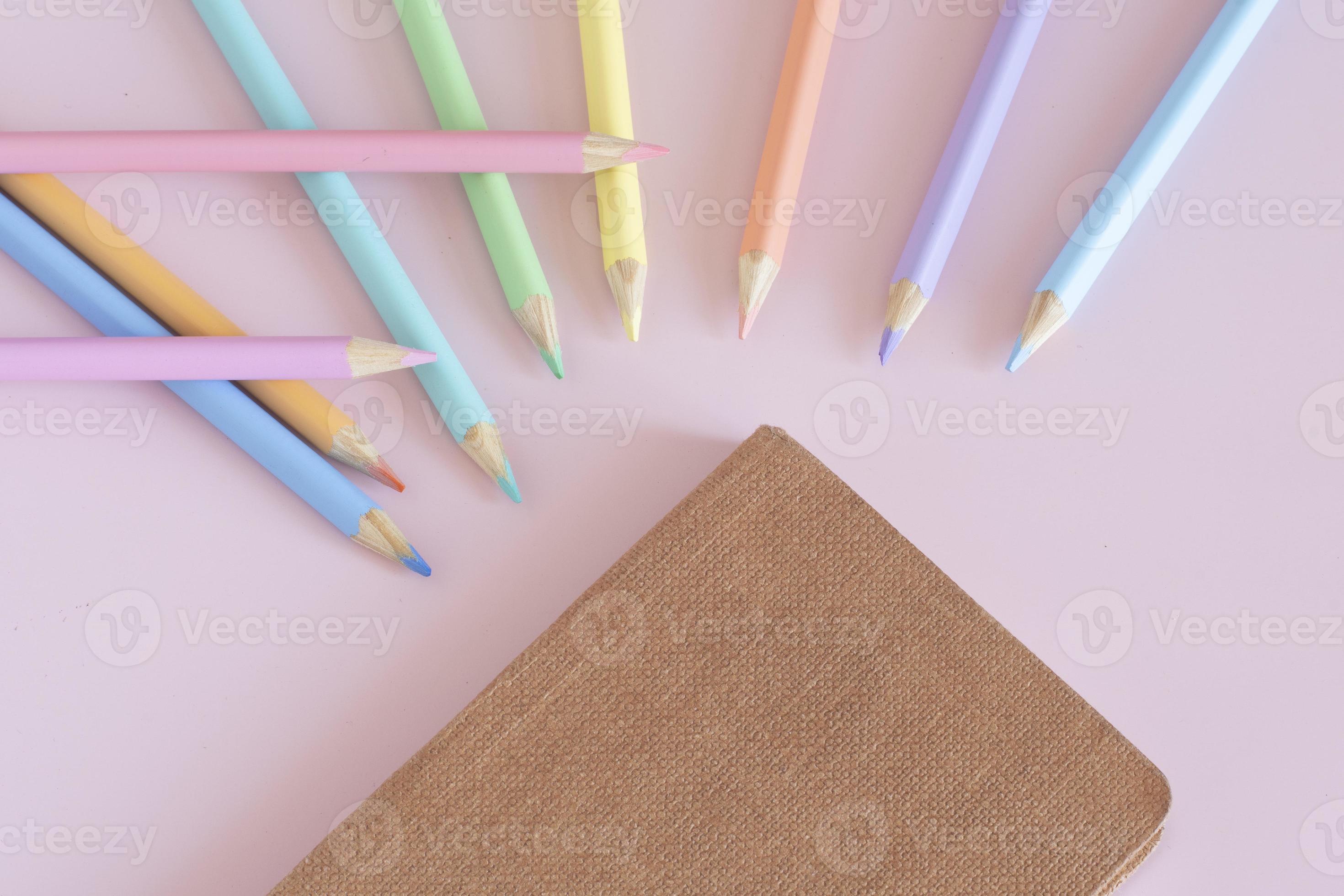 Pastel colored pencils, top view on pink background, illustration