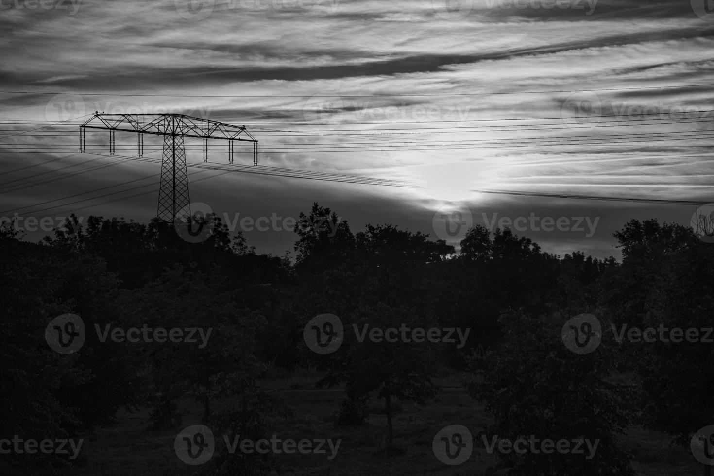 High voltage power pole with overhead line through which electricity is transported photo