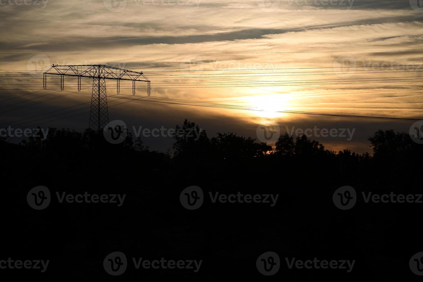 High-voltage power pole with overhead line through which the electricity is transported photo