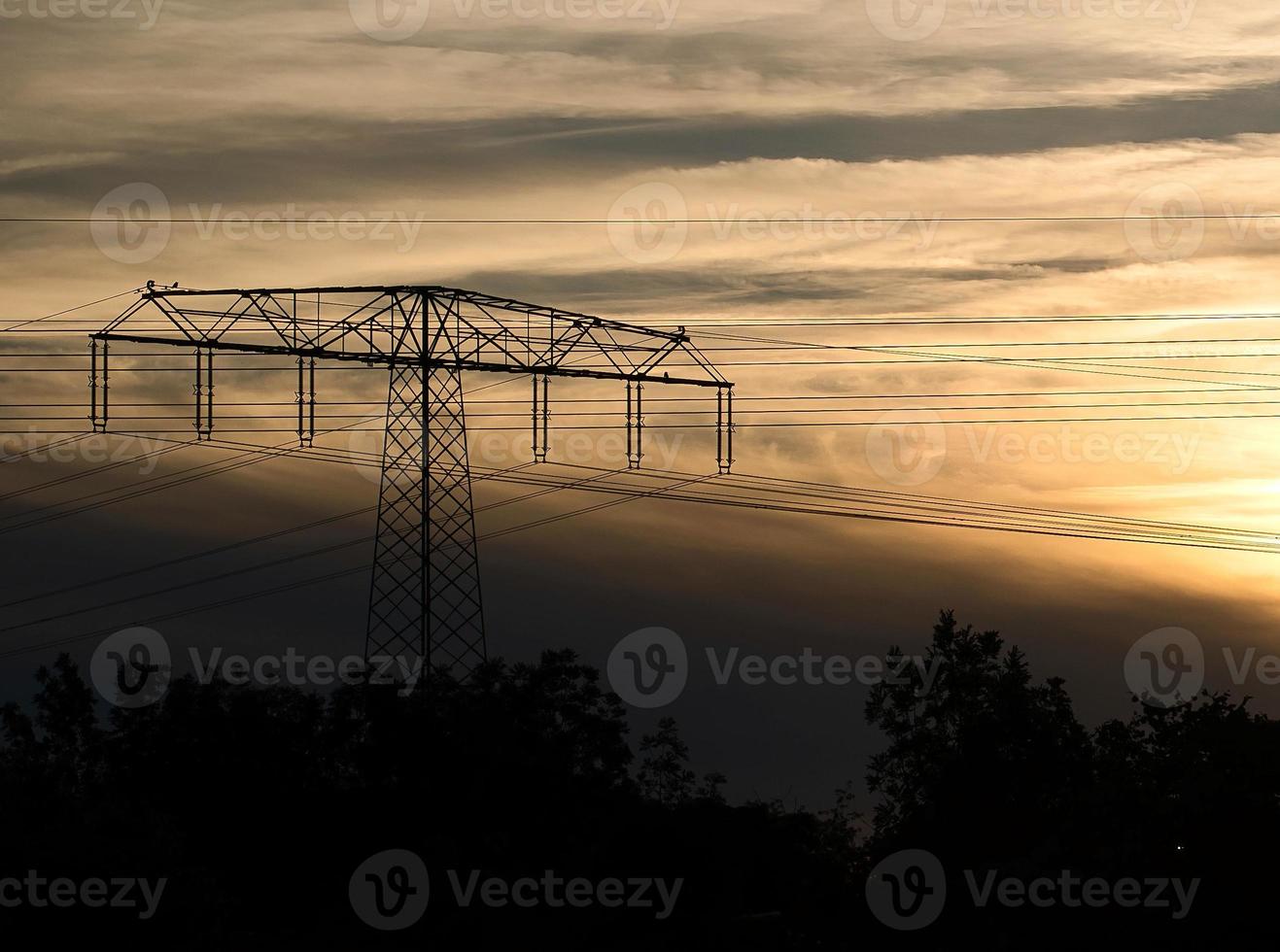 High-voltage power pole with overhead line through which the electricity is transported photo