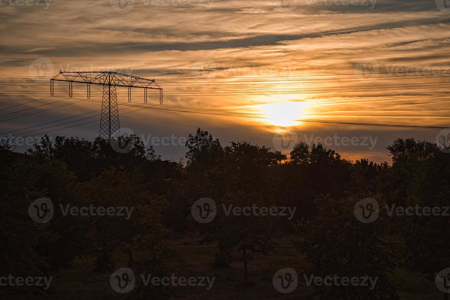 High-voltage power pole with overhead line through which the electricity is transported photo