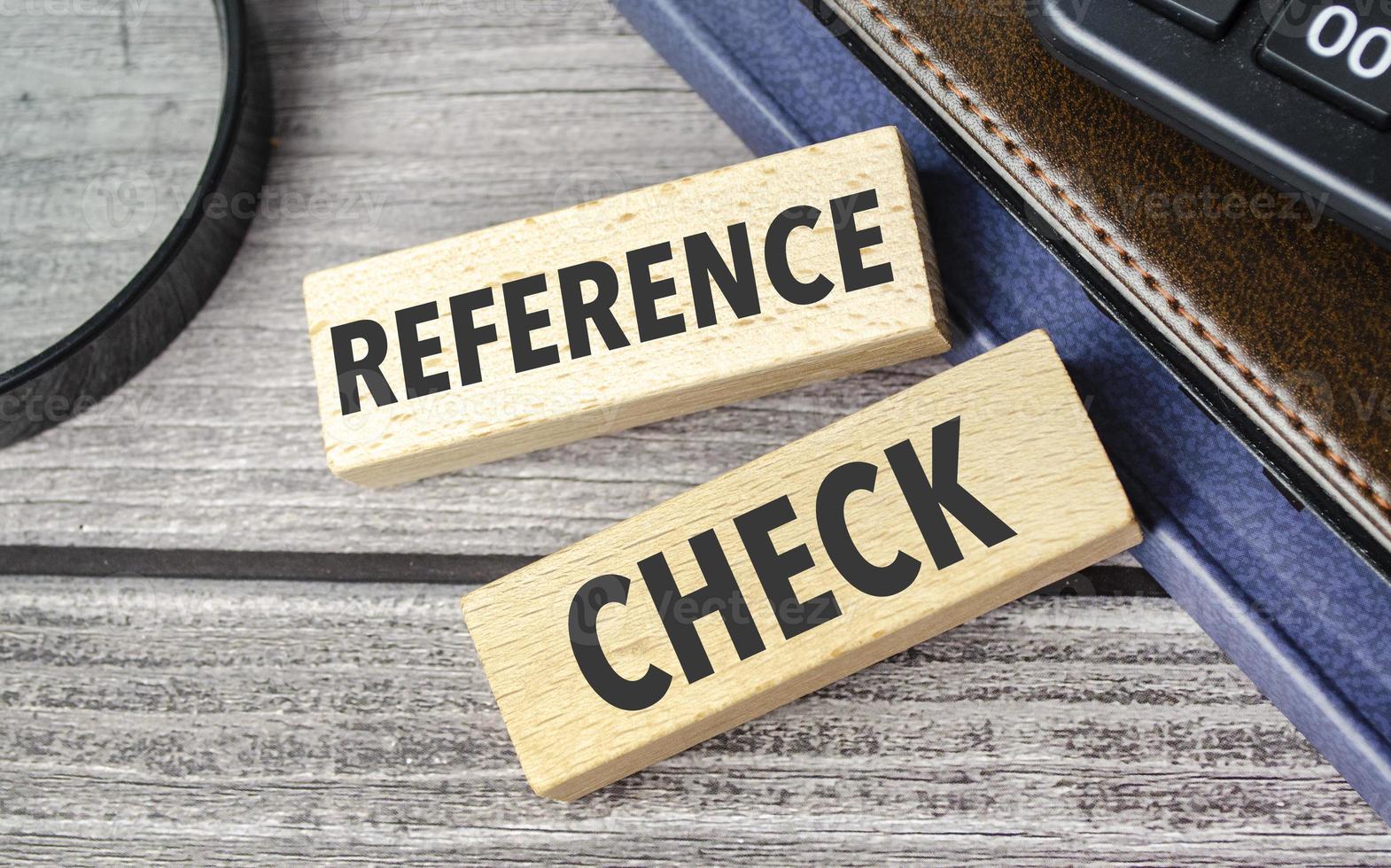 REFERENCE CHECKS. text on wooden blocks on wooden background with office supplies photo