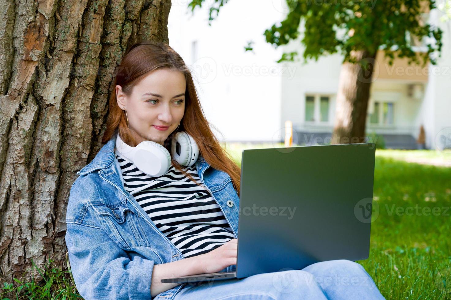 Happy female using laptop for work or education in the parl.Remote edication or work concept photo