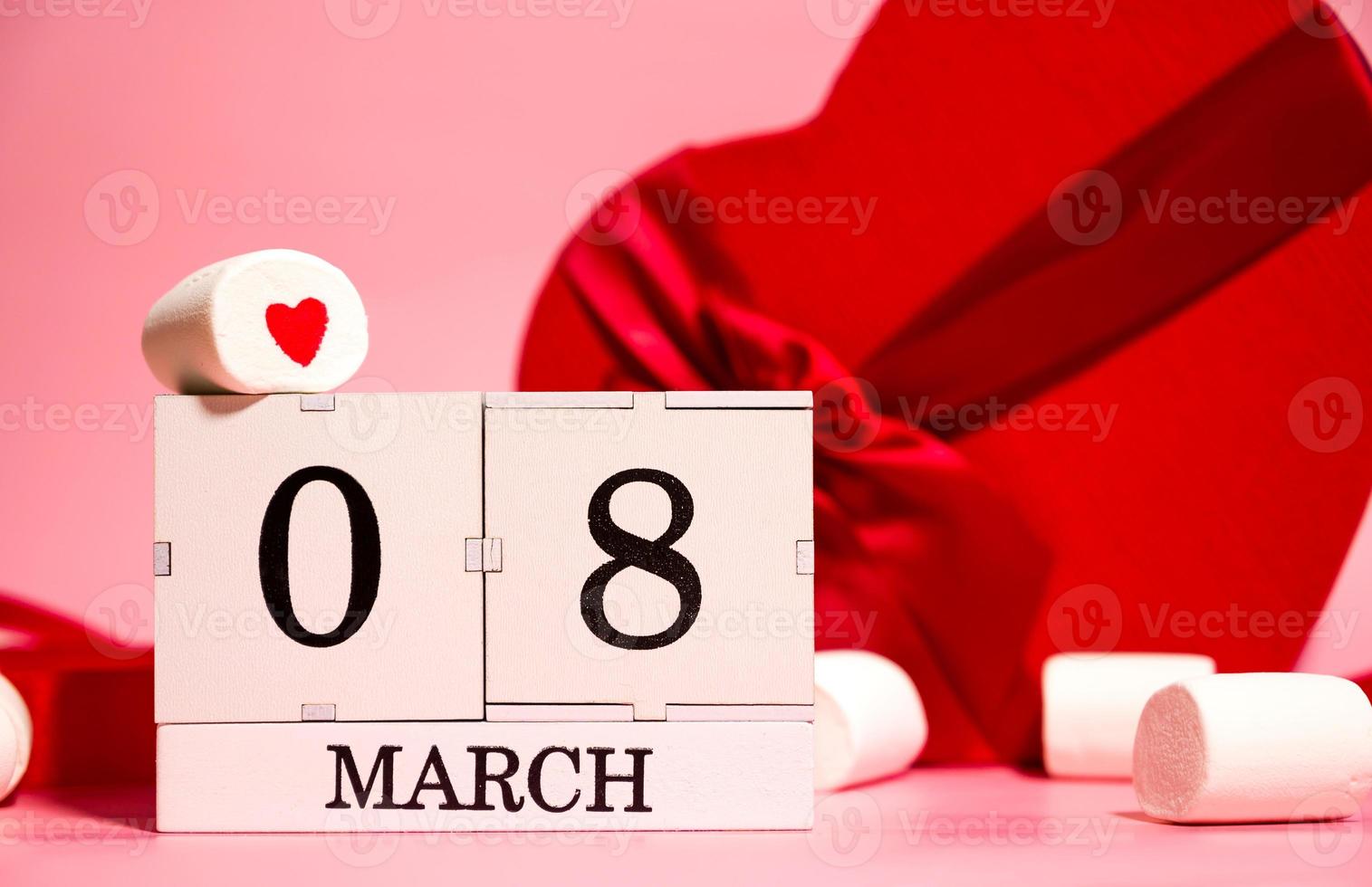 8 march creative card with heart shaped gifts, marshmallows and calendar with 8 march date photo