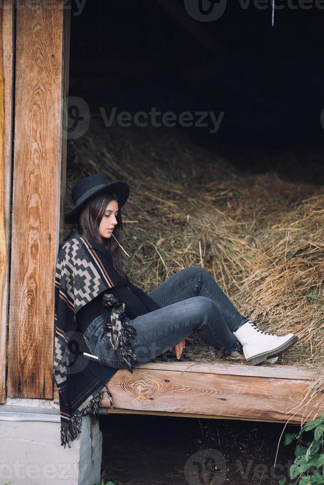 Young brunette woman sitting at the barn. Country style. photo