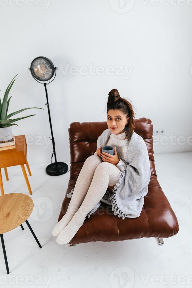 Sweet woman relaxing with hot beverage covered blanket photo