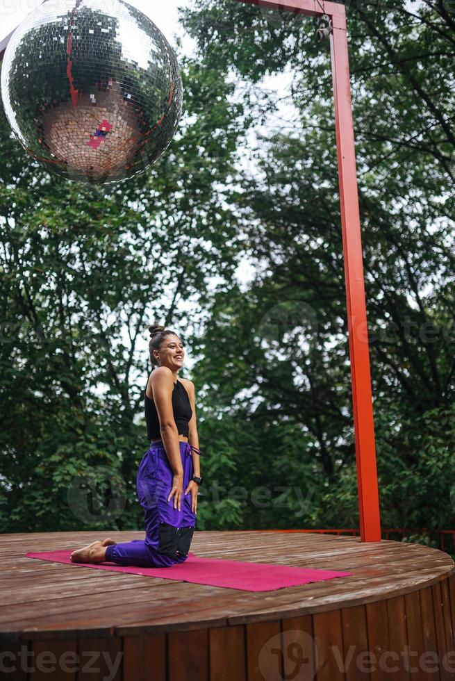 Sporty woman performs kneeling exercises while standing on a mat photo