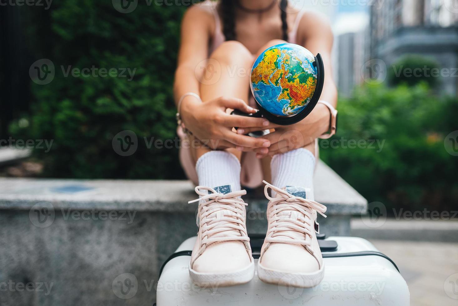 Cropped photo. Beautiful young woman holds a small globe photo