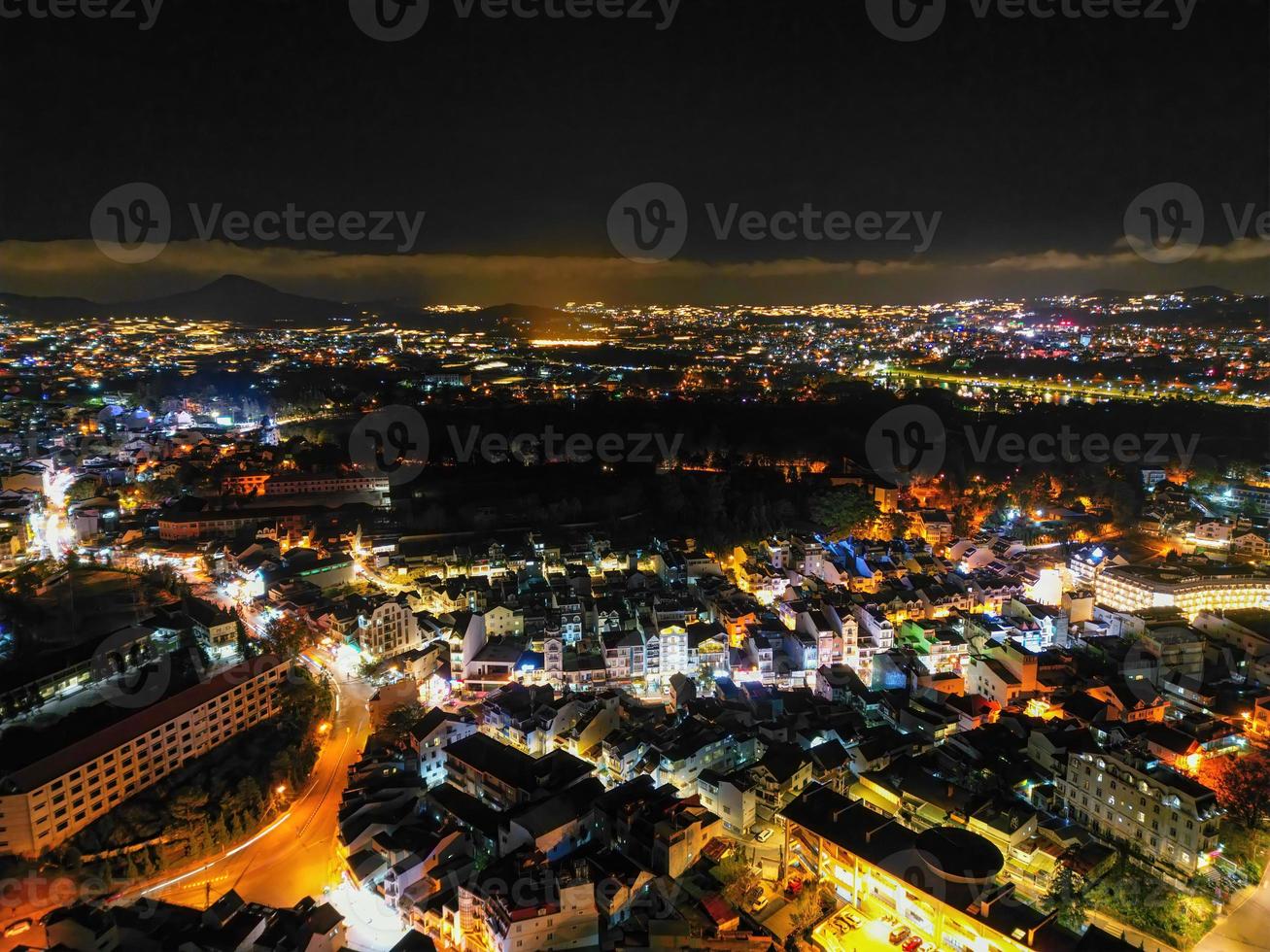 Illuminated Night View of Da Lat City, Vietnam A Captivating Display of City Lights against the Dark Starry Sky photo