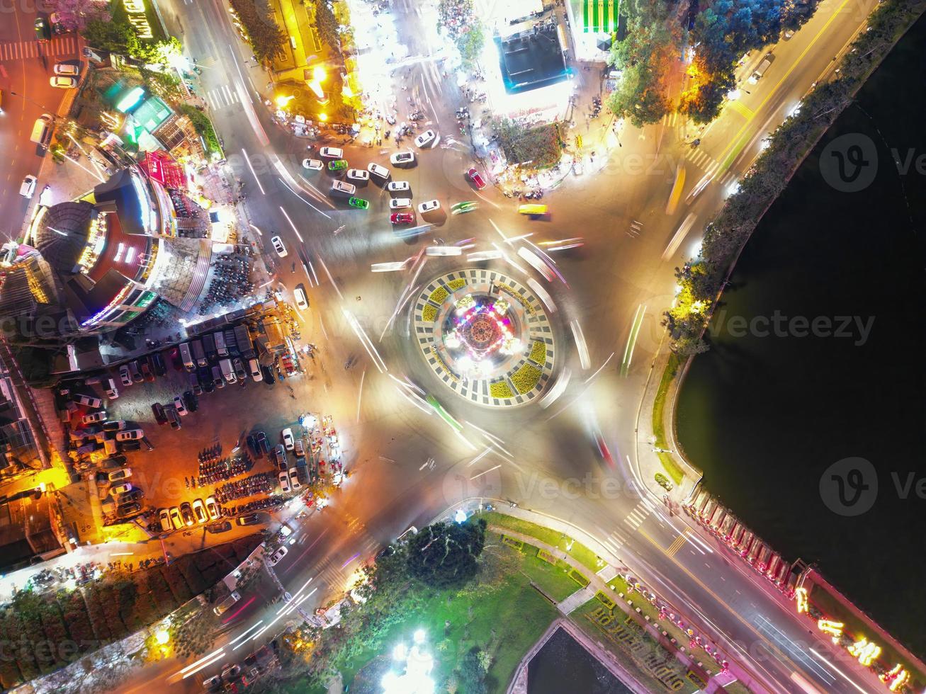 Captivating Timelapse of Nighttime Traffic in Da Lat City, Vietnam A Mesmerizing View of Roundabout, Vehicles and City Lights in Motion photo