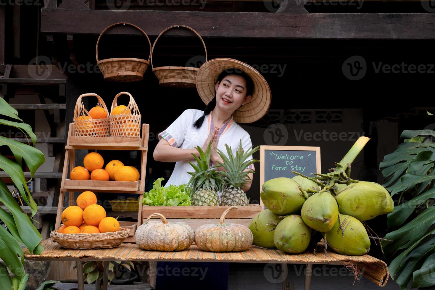 Indigenous Asian women raise their hands pay respect to greet tourists with a natural assortment of fruits to welcome tourists to the farm stay. Homestay in Thailand Loei photo