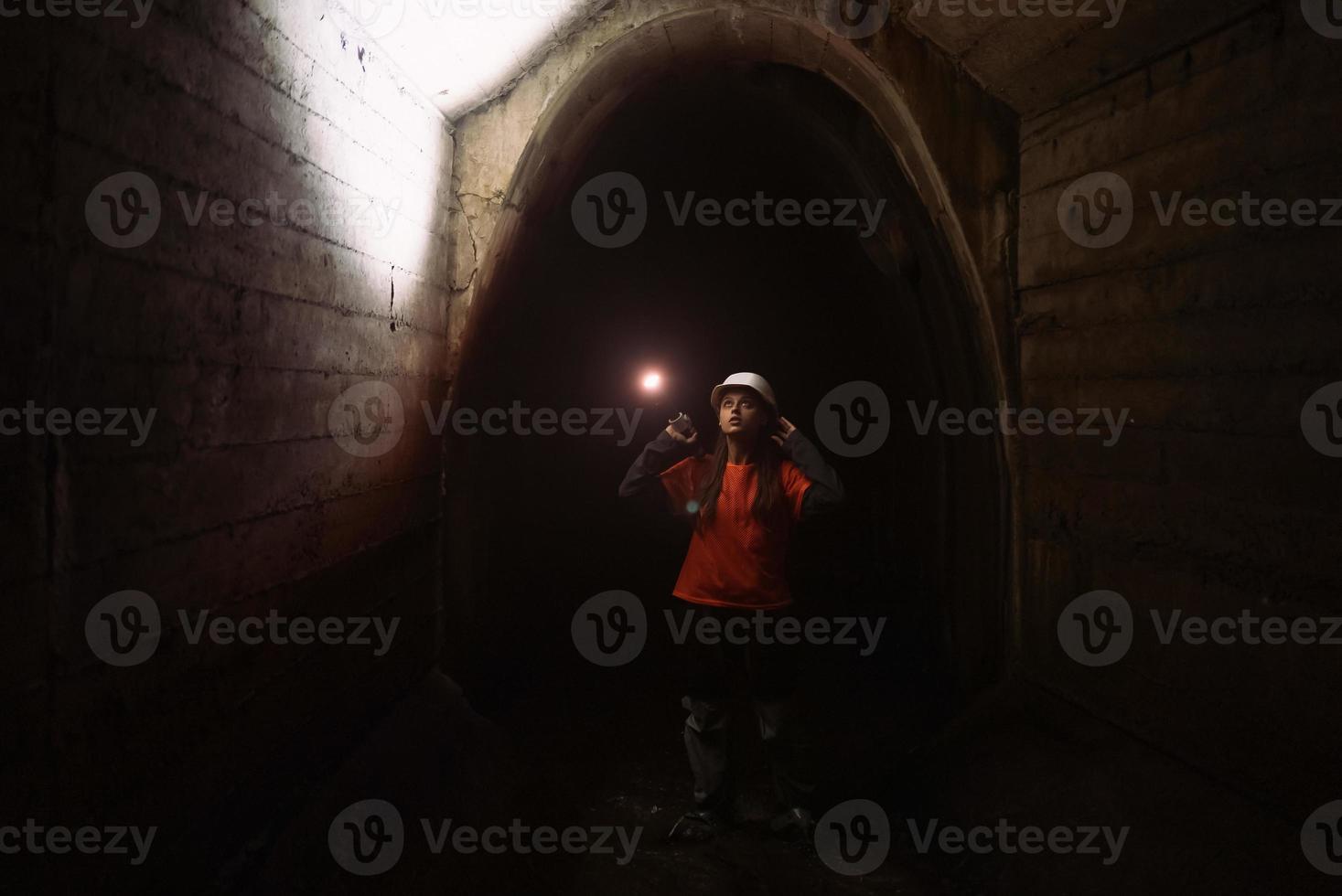 Female digger with flashlight explores the tunnel photo