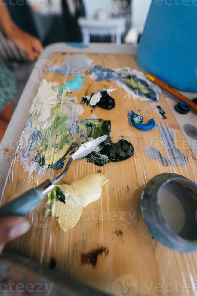 Close up of woman's hand mix paints in palette photo