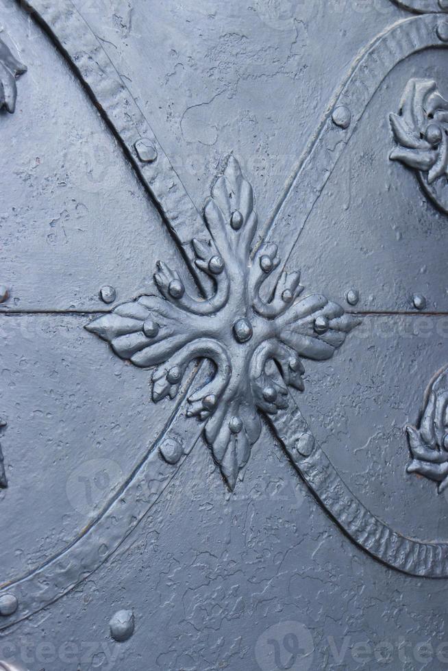 Close up fragment of medieval metal doors with decorative elements. Part of antique old door photo