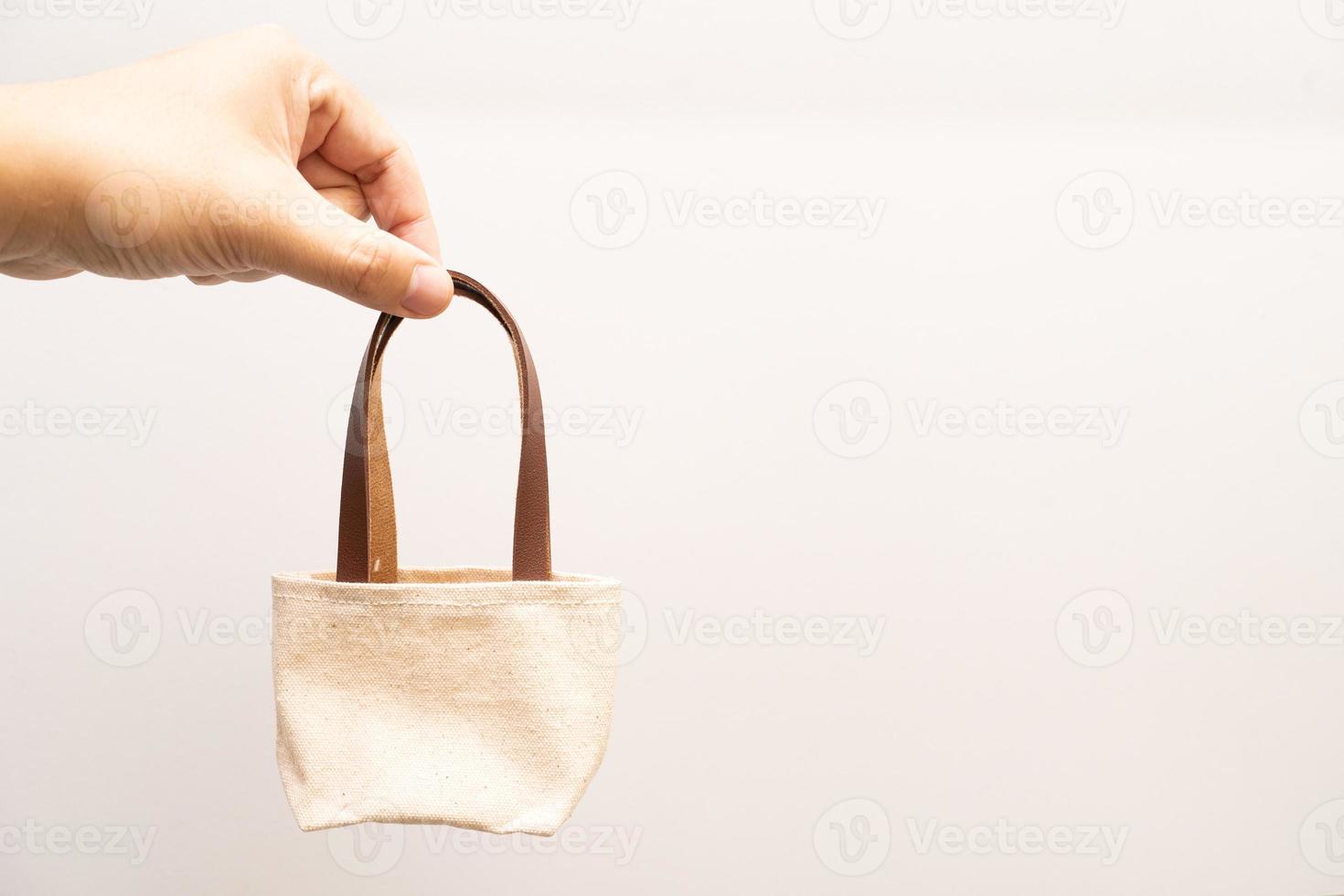 small full canvas bag with ties, Reusable eco bag. Empty small cotton bag with string on white background. photo