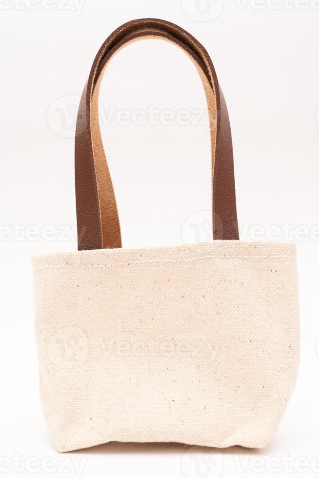 small full canvas bag with ties, Reusable eco bag. Empty small cotton bag with string on white background. photo
