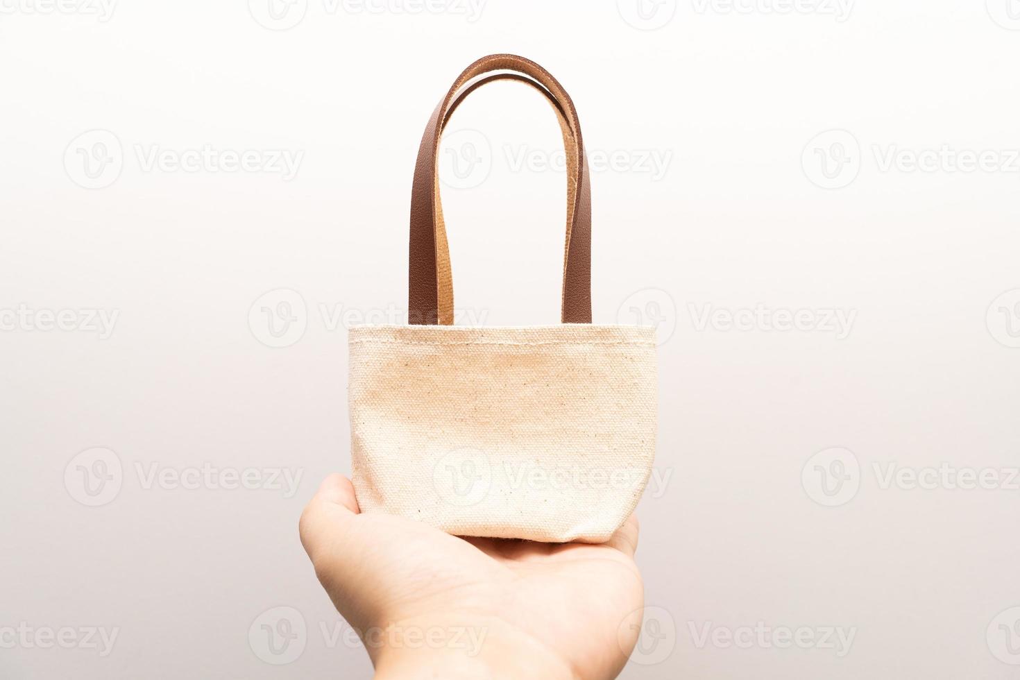 small full canvas bag with ties, Reusable eco bag. Empty small cotton bag with string on white background. photo