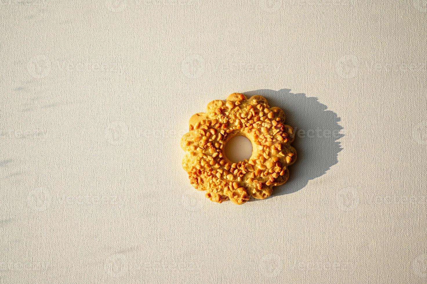 Sand ring with nuts, isolated. Two cookies in the shape of a ring, sprinkled with peanuts. White background photo