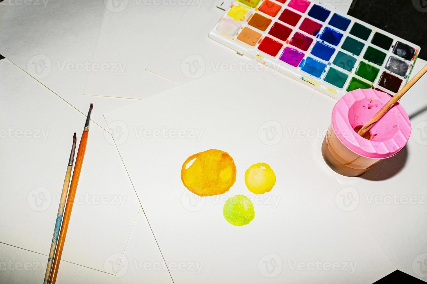 Watercolor paints, on the table. A child draws. photo