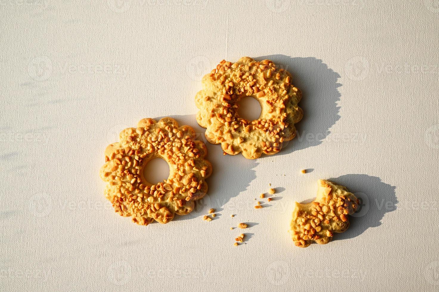 Sand ring with nuts, isolated. Two cookies in the shape of a ring, sprinkled with peanuts. White background photo