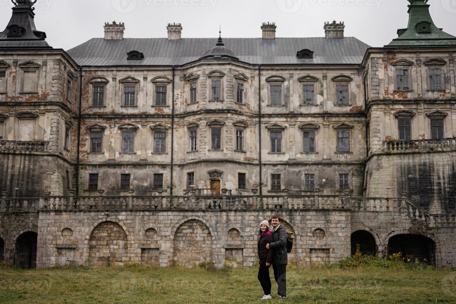 Couple tourists against Pidhirtsi Castle, Lviv region, Ukraine. photo