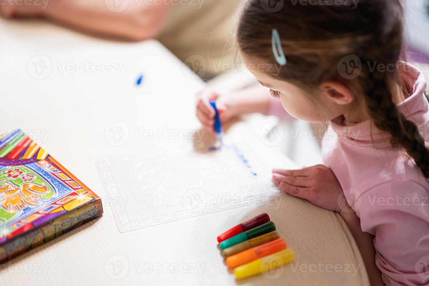 Girl decorating art with glitter decor pencil. photo