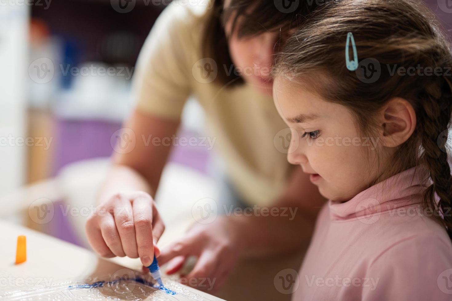 Mother and daughter decorating art with glitter decor. photo