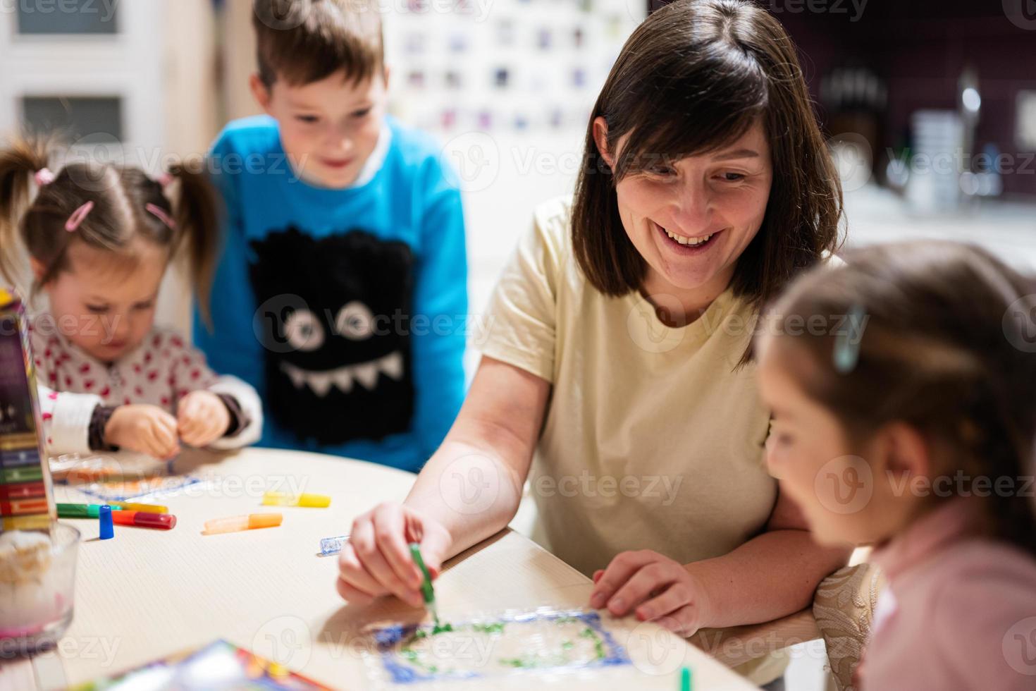 madre y niños decorando Arte con Brillantina decoración. foto