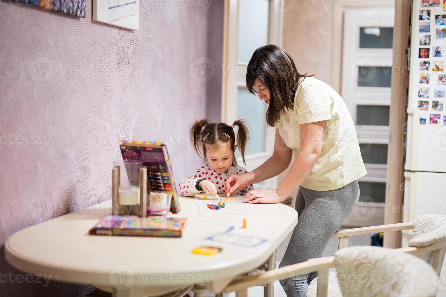 Mother and daughter decorating art with glitter decor. photo