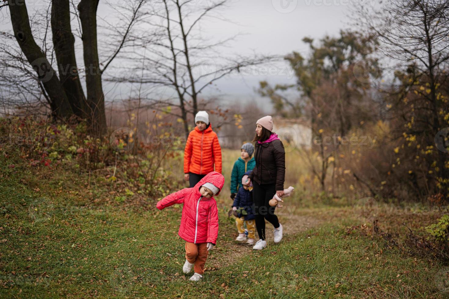 Mother with her four kids in autumn forest. photo