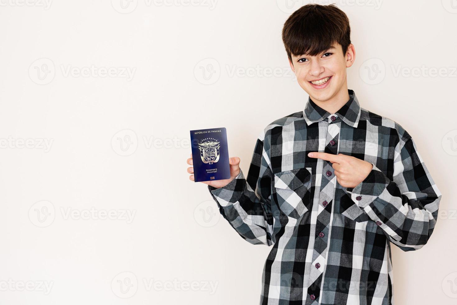 joven adolescente chico participación Panamá pasaporte mirando positivo y contento en pie y sonriente con un confidente sonrisa en contra blanco antecedentes. foto