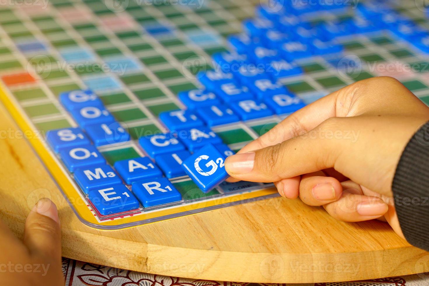 Asian high school students are competing in a Crossword or Scrabble game, an English word puzzle game. It is a game that promotes English learning and critical thinking skills. photo
