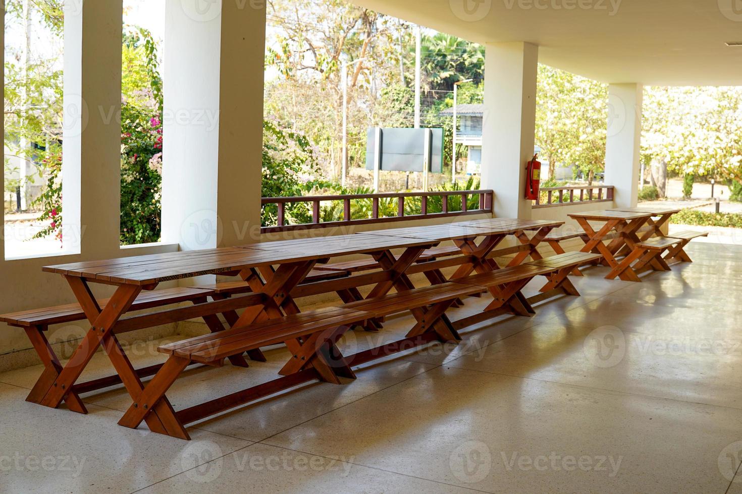long wooden table placed under the building for sitting, relaxing, working. Soft and selective focus. photo