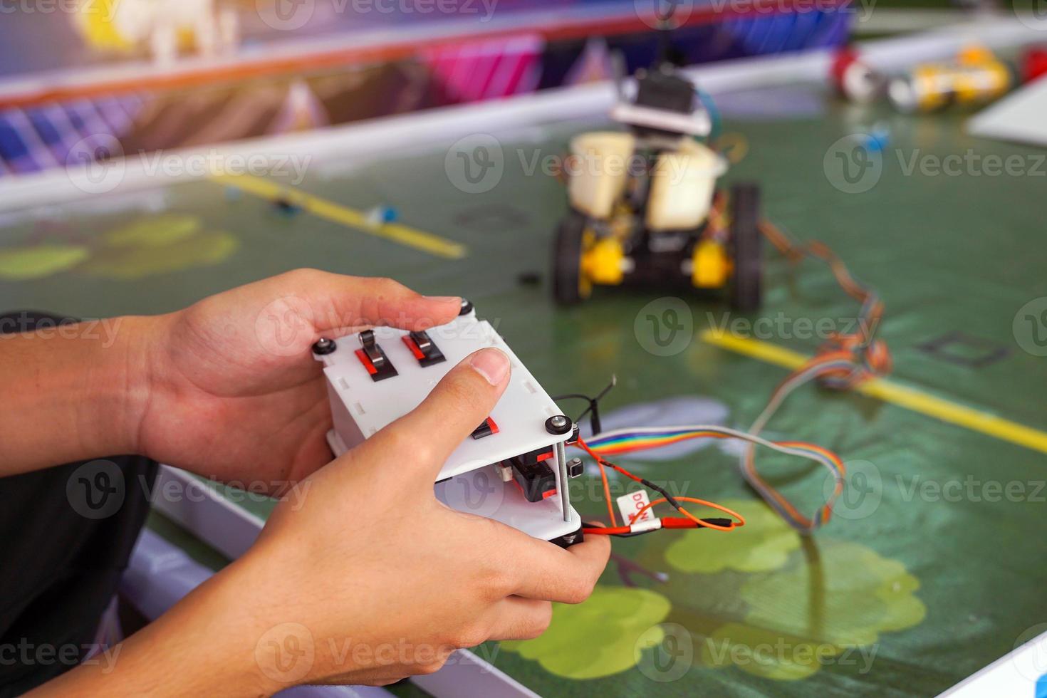Asian high school students practice moving robots on the playing field To perform missions according to the rules of the robot competition. Soft and selective focus. photo