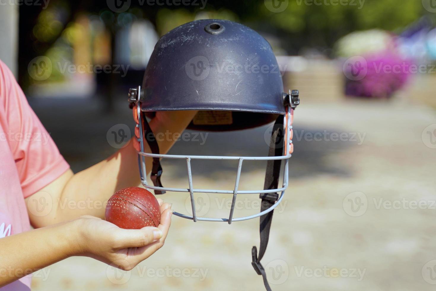 Grillo jugador participación Grillo casco y Grillo pelota en mano antes de yendo a el campo a práctica. suave y selectivo enfocar. foto