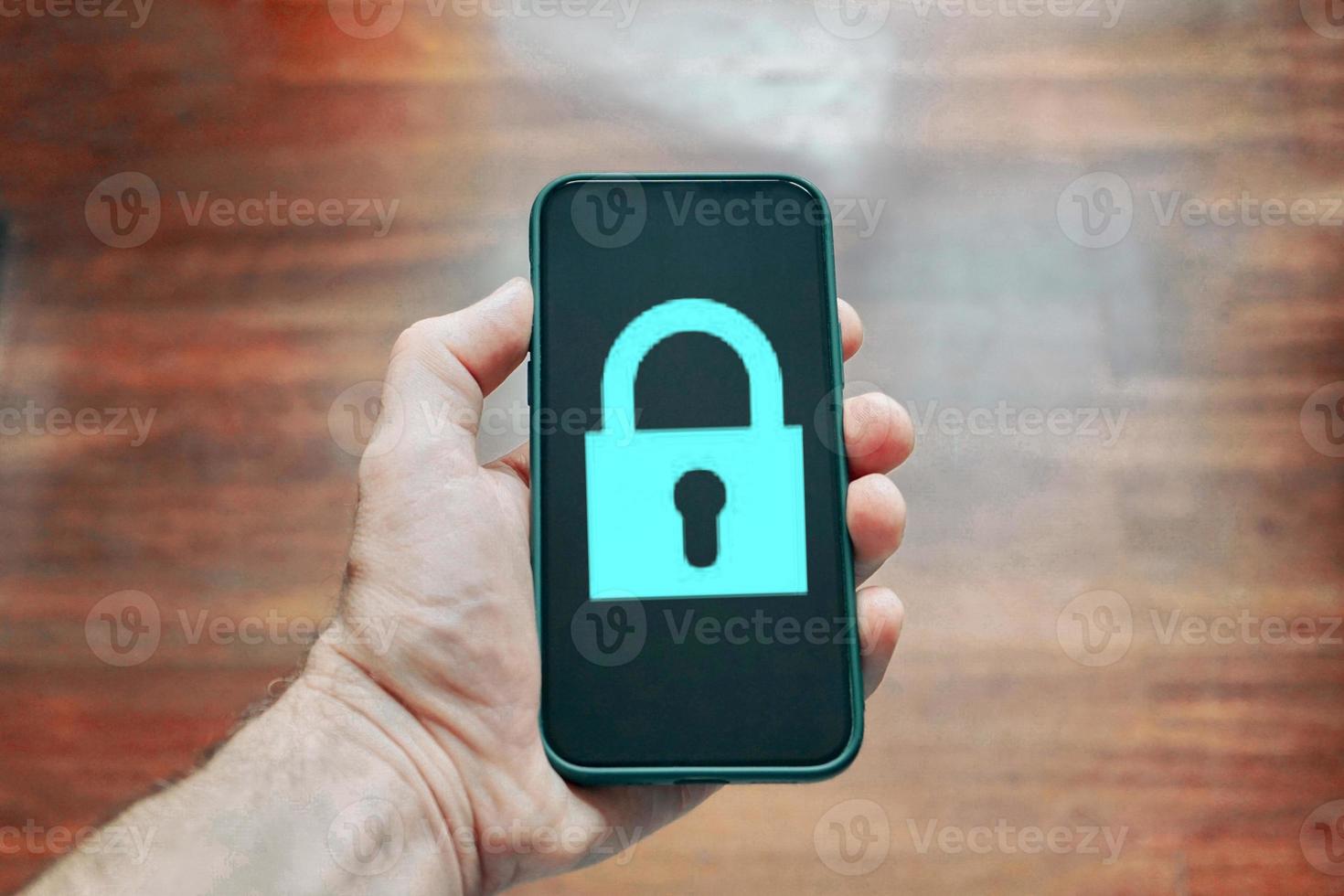hand holding a phone with a padlock security symbol photo