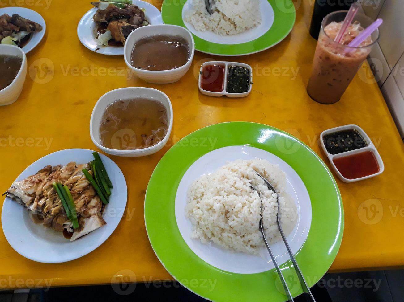 dos porciones de malaca especialidad hainan arroz, un parte de nasi lemak con Fresco salsa y un delicioso A la parrilla pollo pecho foto