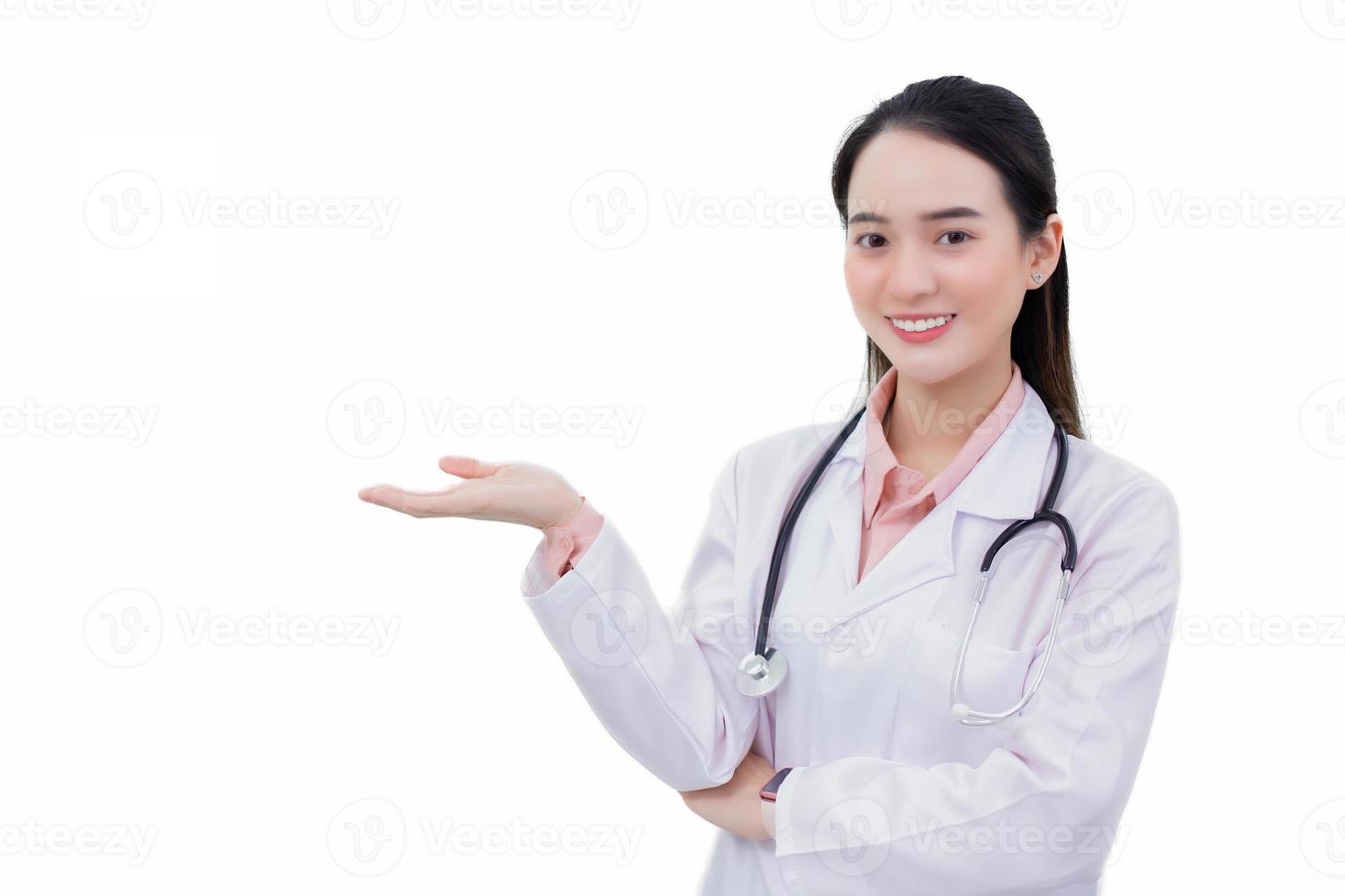profesional asiático mujer médico usa médico Saco mientras en pie con confianza sonriente y muestra su mano a presente alguna cosa aislado en blanco antecedentes en salud proteccion concepto. foto